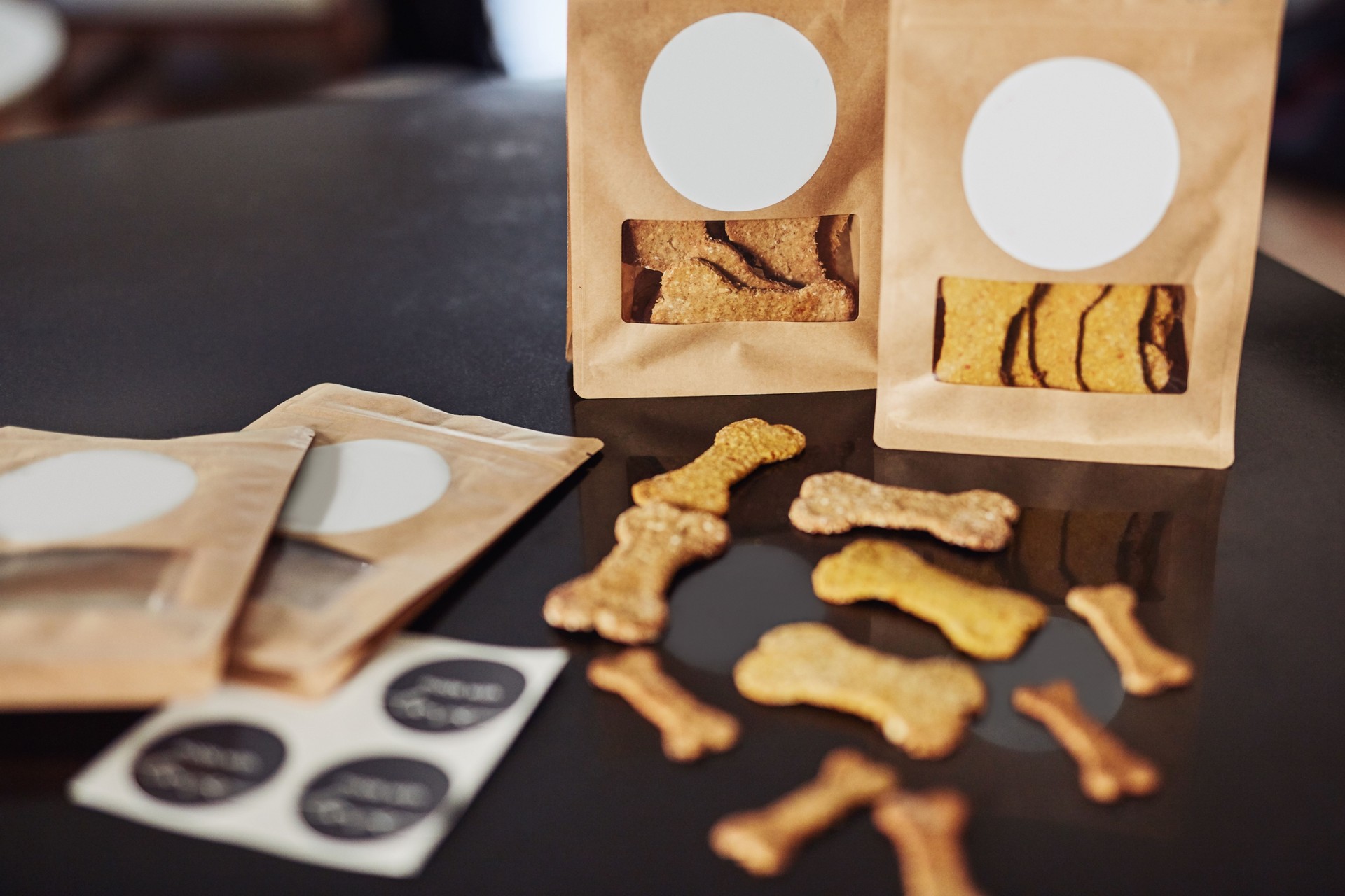 Shot of freshly baked dog biscuits and packaged orders on a kitchen counter during the day